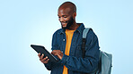 Black man, student and research with tablet in studio for higher education on a blue background. Male person, academic or learner with smile, bag or technology for online learning course or study app