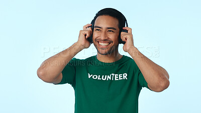 Buy stock photo Volunteer, thinking and happy man with headphones, music and planning of charity project with audio. Blue background, reflection or person with social responsibility, radio and mockup space in studio