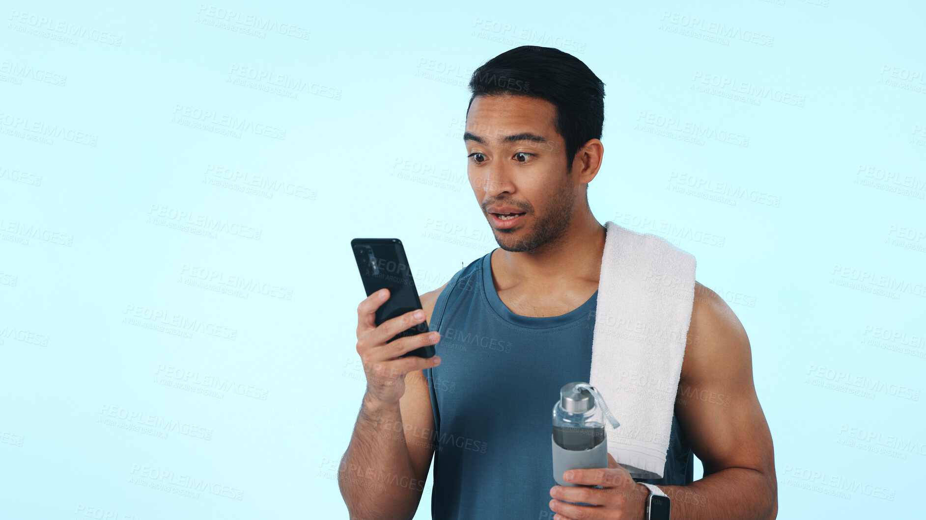Buy stock photo Fitness, phone and surprise with man in studio for gym membership discount, news or chat. Health app target, wellness goals and space with person on blue background for shock and online leaderboard