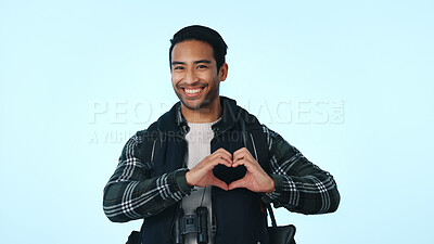 Buy stock photo Heart hands, travel and portrait of man in studio for vacation, support and hiking adventure. Backpacking, tourism and love with person on blue background for happiness, holiday and confidence