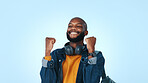 Happy, black man and winning with fist pump in studio for good news on a blue background. Excited, male person or student with smile for achievement, accomplishment or celebration on mockup space