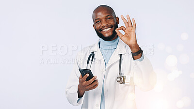 Buy stock photo Phone, okay sign and portrait of doctor in studio for medical support, telehealth and healthcare service. Bokeh, space and black man for medicine, medicare and online consulting on white background