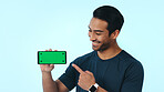 Green screen, online and happy man with phone, pointing and recommendation for social media and web. White background, marketing and person with smile for mobile, promotion and technology in studio