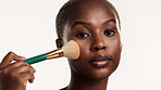 Portrait, beauty and black woman in studio with makeup brush, application and product for cosmetics. Person, self care and tools for grooming routine, glow and apply foundation on white background.