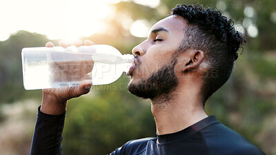 Buy stock photo Nature, fitness and man drinking water outdoor on break for exercise, running or training. Sports, athlete and male person with health beverage for hydration, thirsty or wellness  for workout in park