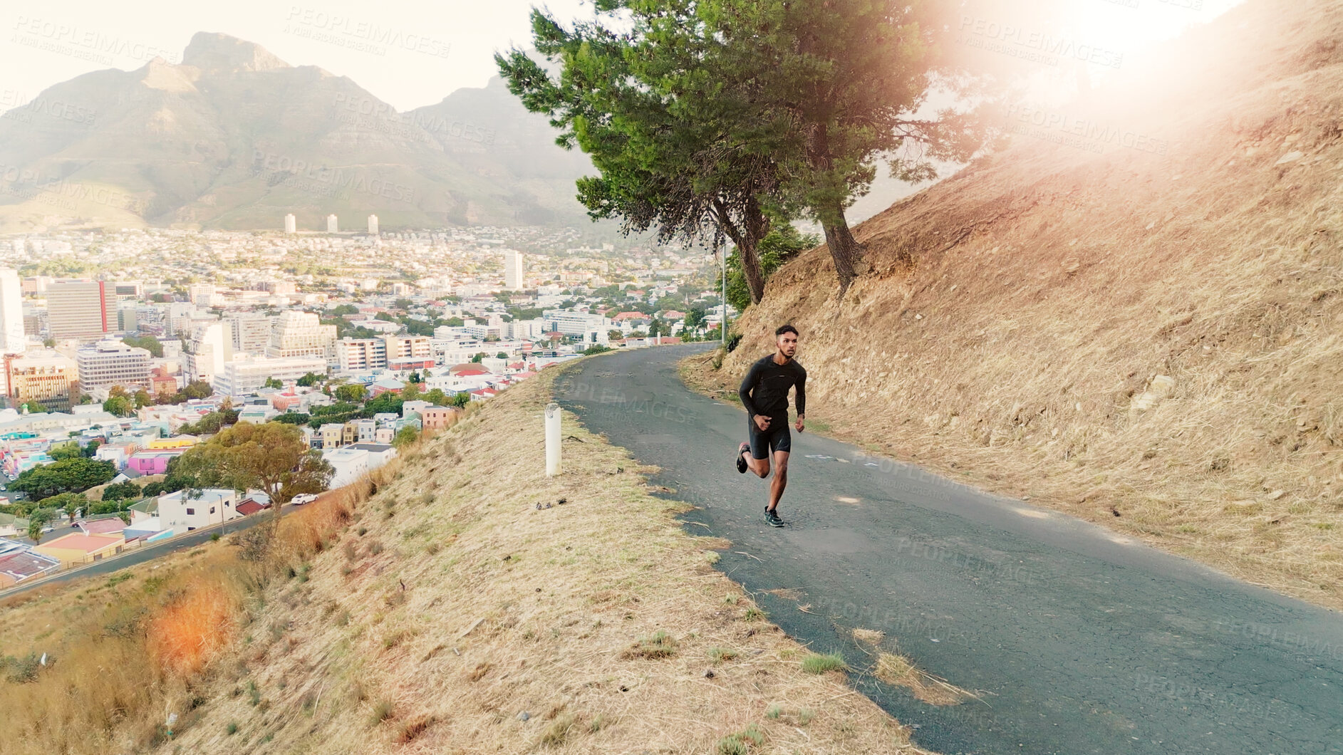 Buy stock photo Man, running and training on mountain road for fitness, leg muscle development and exercise for cardio. Male person, runner or jogging on nature trail for healthy body, outdoor challenge and wellness