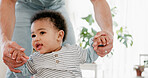 Holding hands, baby and father teaching to walk, support or mobility development in home. Child, parent and infant with first steps for motor skills, growth or help for learning balance while bonding