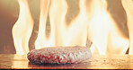 Grill, burger and patty in restaurant with fire, cuisine preparation or cooking meat for fast food. Flame, raw beef and protein in kitchen with steam, catering service and hospitality for lunch meal.