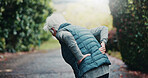 Fitness, injury and old person with back pain at park, exercise and discomfort with muscle pressure. Outdoor, space and senior runner with joint strain after training accident, workout or bad posture