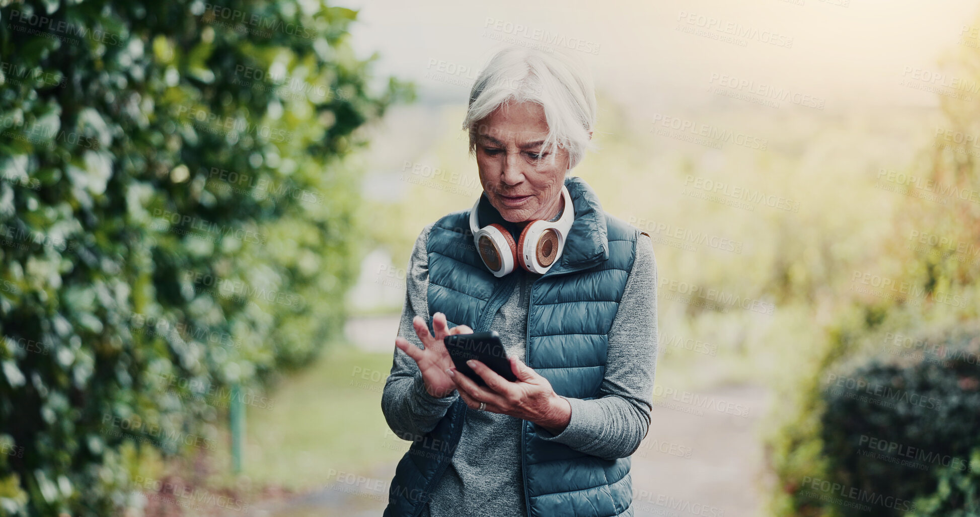 Buy stock photo Outdoor, reading or old woman with phone for fitness, running route research or find training playlist. Park, workout app or senior person with tech for trail navigation, steps count or music search