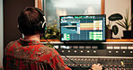 Computer screen, headphones and music with man in studio for recording or sound engineering. Display, production and synthesizer with DJ person in control room for balance or mixing from back