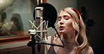 Creative, woman and singing in recording studio with microphone, song performance and music production. Artist, person and singer at record label with gear, talenr and sound track for album project.