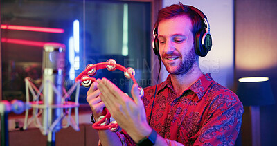 Buy stock photo Music, production and man with tambourine in studio for entertainment, recording and sound media. Artist, headphones and musician in neon with microphone for audio, broadcast or performance of song