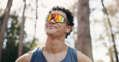 Buy stock photo Thinking, athlete and man with earphones in nature, music and plan for exercise on break or fitness. Outdoor, runner and person with tech for audio, low angle and workout reflection for wellness