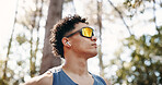 Thinking, athlete and man with earphones on break, music and plan for exercise in nature or fitness. Outdoor, runner and person with tech for audio, low angle and workout reflection for wellness