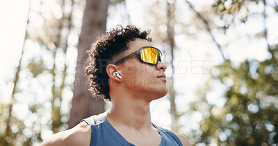 Buy stock photo Thinking, athlete and man with earphones on break, music and plan for exercise in nature or fitness. Outdoor, runner and person with tech for audio, low angle and workout reflection for wellness