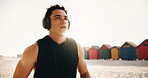 Athlete, thinking and man with headphones at sea, fitness or memory of wellness with music playlist. Outdoor, runner and person with tech for audio, resting and reflection after exercise and flare