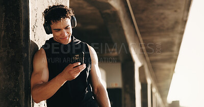 Buy stock photo Fitness, city and man by bridge with phone for social media after training, exercise and break. Sports, athlete and person on smartphone with headphones for health app, internet and music outdoor