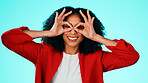 Binocular, hands and woman with expression portrait in studio for playful gesture, vision or funny face. Happy female person, comic finger glasses and blue background for joke, frame or perspective