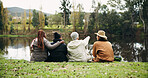 Friends, relax and talk at park by lake, point or embrace on hiking trip, break and nature tourism. People, group and travel for view on grass, dam and outdoor for sightseeing with rest on holiday