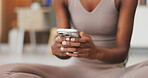 Hands, fitness and phone with black woman in home for communication, health app and break. Social media, yoga pose search and connection with person and mobile in living room of house for wellness