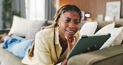 Buy stock photo Black woman, tablet and relax on sofa in home with funny post, gossip and thinking in living room. African person, tech and happy with application, notification or surprise on social media at house