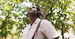 Black man, thinking and smile at park with headphones, streaming or listen to music on commute in summer. African person, happy and tourism with sightseeing, sound or audio subscription in nature