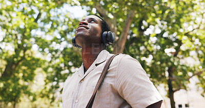 Buy stock photo Black man, thinking and smile at park with headphones, streaming or listen to music on commute in summer. African person, happy and tourism with sightseeing, sound or audio subscription in nature