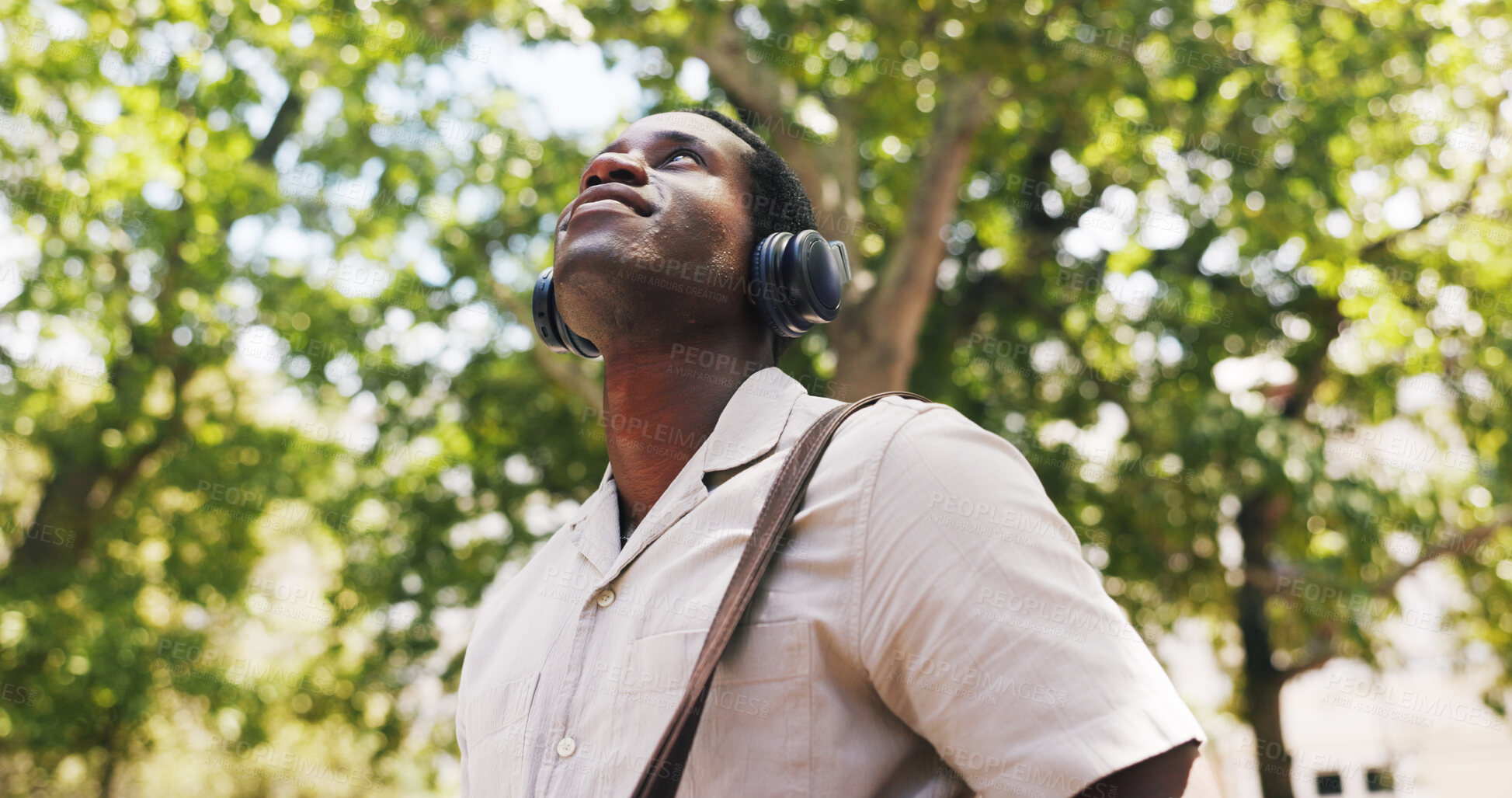Buy stock photo Black man, thinking and smile at park with headphones, streaming or listen to music on commute in summer. African person, happy and tourism with sightseeing, sound or audio subscription in nature