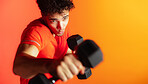 Man, dumbbells and fitness in studio with punch, confidence and mock up space on orange background. Person, boxer and martial arts with weightlifting for power, exercise and workout for muscle growth