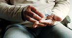 Senior, patient and hands with pills for medication, arthritis or antibiotics on wheelchair in home. Closeup, elderly or person with a disability taking tablets in container for medical prescription
