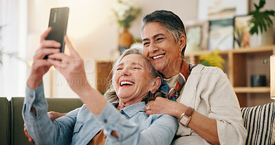 Buy stock photo Mature, happy couple and hug with selfie on sofa for picture, photography or memory together in home. Female people, LGBTQ or lesbians with smile for capture moment, funny post or social media app