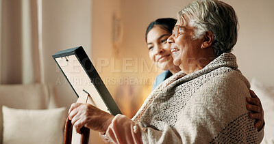 Buy stock photo Happy, daughter and old woman in home with picture frame, family memories or love for bonding together. Senior mother, smile and people in lounge with photograph, nostalgia and remember past history.