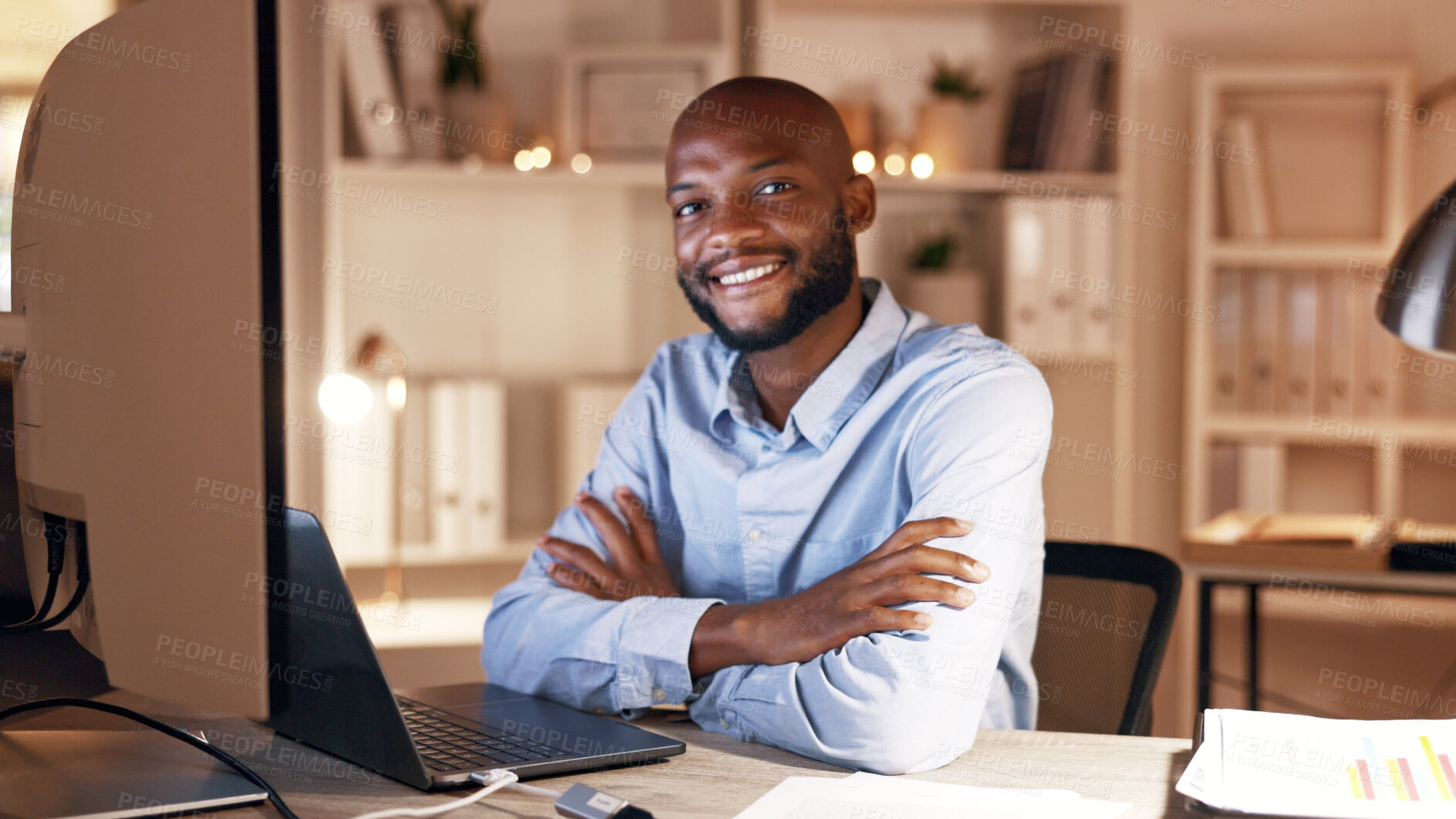 Buy stock photo Businessman, arms crossed and smile with laptop in office, portrait and working late for investment. Night, actuary and black person with tech for risk assessment, happy or pride for project in Kenya