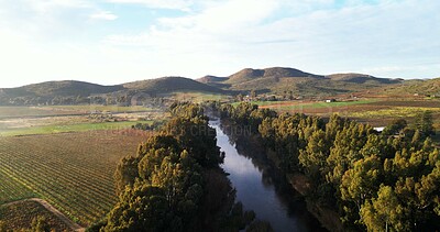 Buy stock photo River, above and countryside with nature, mountains and blue sky with trees, sunshine and agriculture. Empty, clouds and landscape with lake, farm land and growth with view and sustainability