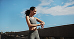 City, runner and woman with smart watch for exercise progress, health app and fitness tracker. Sports, happy and person check time for training, workout and active hobby for wellness with blue sky