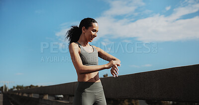 Buy stock photo City, runner and woman with smart watch for exercise progress, health app and fitness tracker. Sports, happy and person check time for training, workout and active hobby for wellness with blue sky
