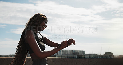 Buy stock photo Happy, runner and black woman with watch in city for exercise, health app and fitness tracker. Sports, space and person check time for training, workout progress and active hobby with blue sky