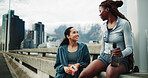 Women, friends and smile for fitness, rest and communication for outdoor training on street. City bridge, chat and people with exercise break for health, workout or marathon practice together