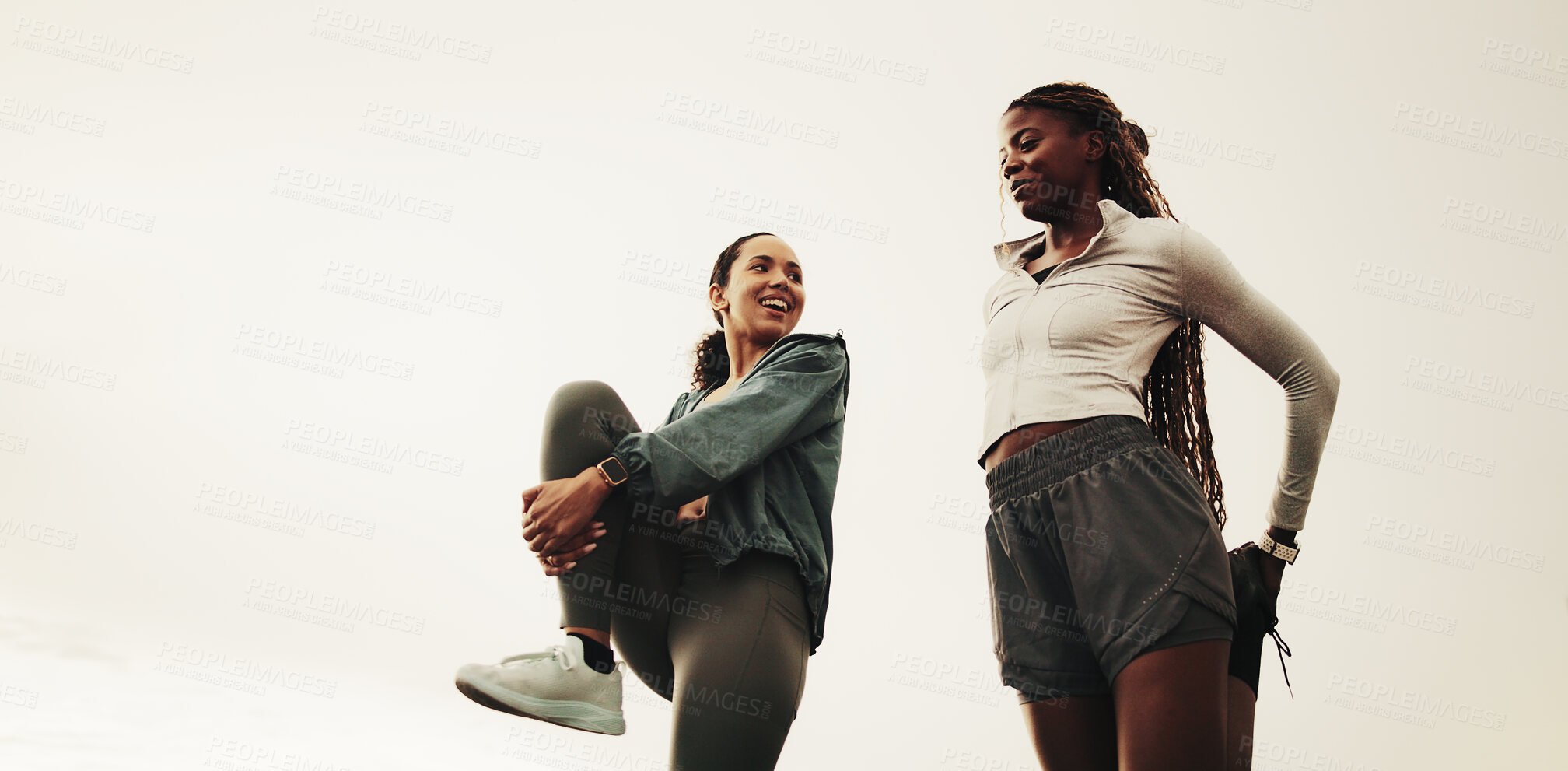 Buy stock photo Women, friends and stretching for workout, warm up and routine for outdoor training with smile. Low angle, chat and people with leg exercise for fitness, endurance or marathon practice together