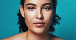 Studio, portrait and skincare for woman for glow, serious and beauty with cosmetics for healthy skin. Blue background, face and person with pride for wellness, dermatology and self care in Brazil
