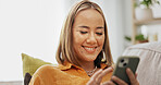 Woman, phone and smile on sofa with social media, communication and networking in living room. Gossip, female person and reading with digital tech for online chatting, texting or mobile app in house