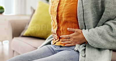 Buy stock photo Pain, stomach and hands of woman on sofa with period cramps, discomfort and indigestion. Home, sick and person with tummy ache, constipation and abdominal issue for medical crisis in living room