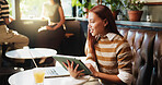 Laptop, remote work and tablet with woman in coffee shop for journalism, planning or research. App, reading and technology with freelance journalist in restaurant booth for editing or piublishing