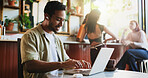 Earphones, laptop and typing with man in coffee shop for editing, journalism or publishing. Computer, listening and remote work with freelance journalist in restaurant cafe for planning or research
