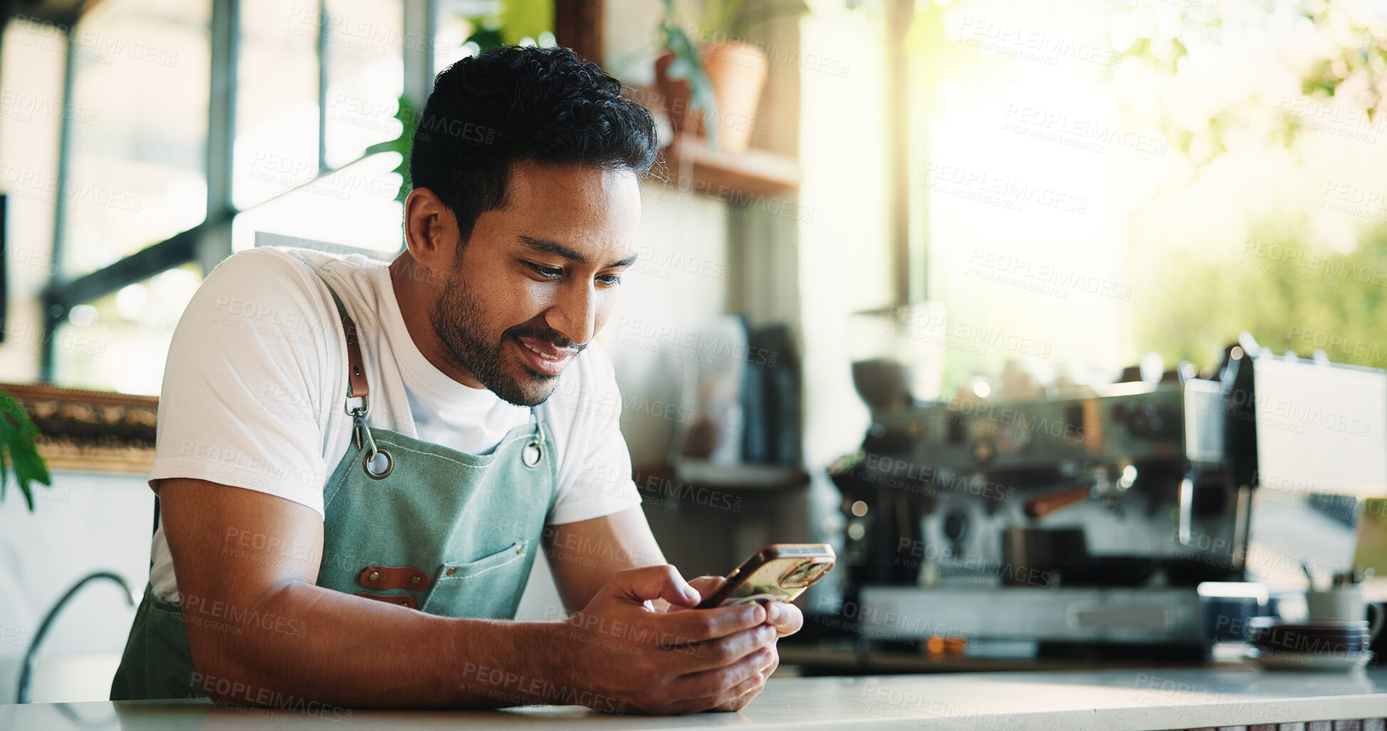 Buy stock photo Message, smile and barista in cafe with phone, chat or social media update on work break. Texting, happy or man in restaurant with tech, business review or online communication in free time.