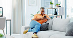 Happy, black woman and relax with phone on sofa for social media, communication or texting in home. Female person, reading and news with smile or mobile smartphone on couch for online chatting app