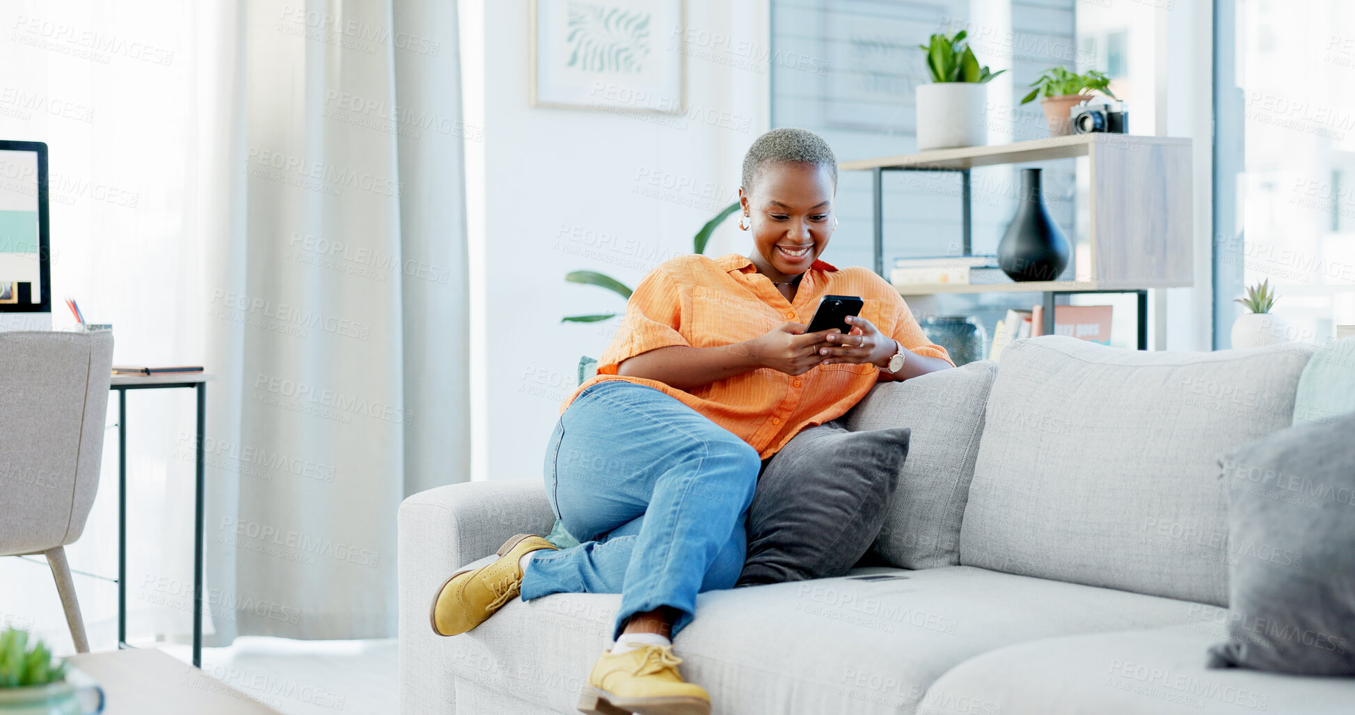 Buy stock photo Happy, black woman and relax with phone on sofa for social media, communication or texting in home. Female person, reading and news with smile or mobile smartphone on couch for online chatting app