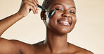 Skincare, facial roller and black woman with beauty, cosmetics or glow by studio background. Happy, face massage and African female person with tool for blood circulation or lymphatic drainage.