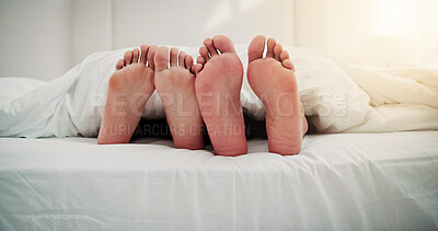 Buy stock photo Home, sleep and feet of couple in bed for resting, love and relax together in morning. Apartment, weekend and people with blanket, duvet and barefoot for cuddle, bonding and relationship in bedroom